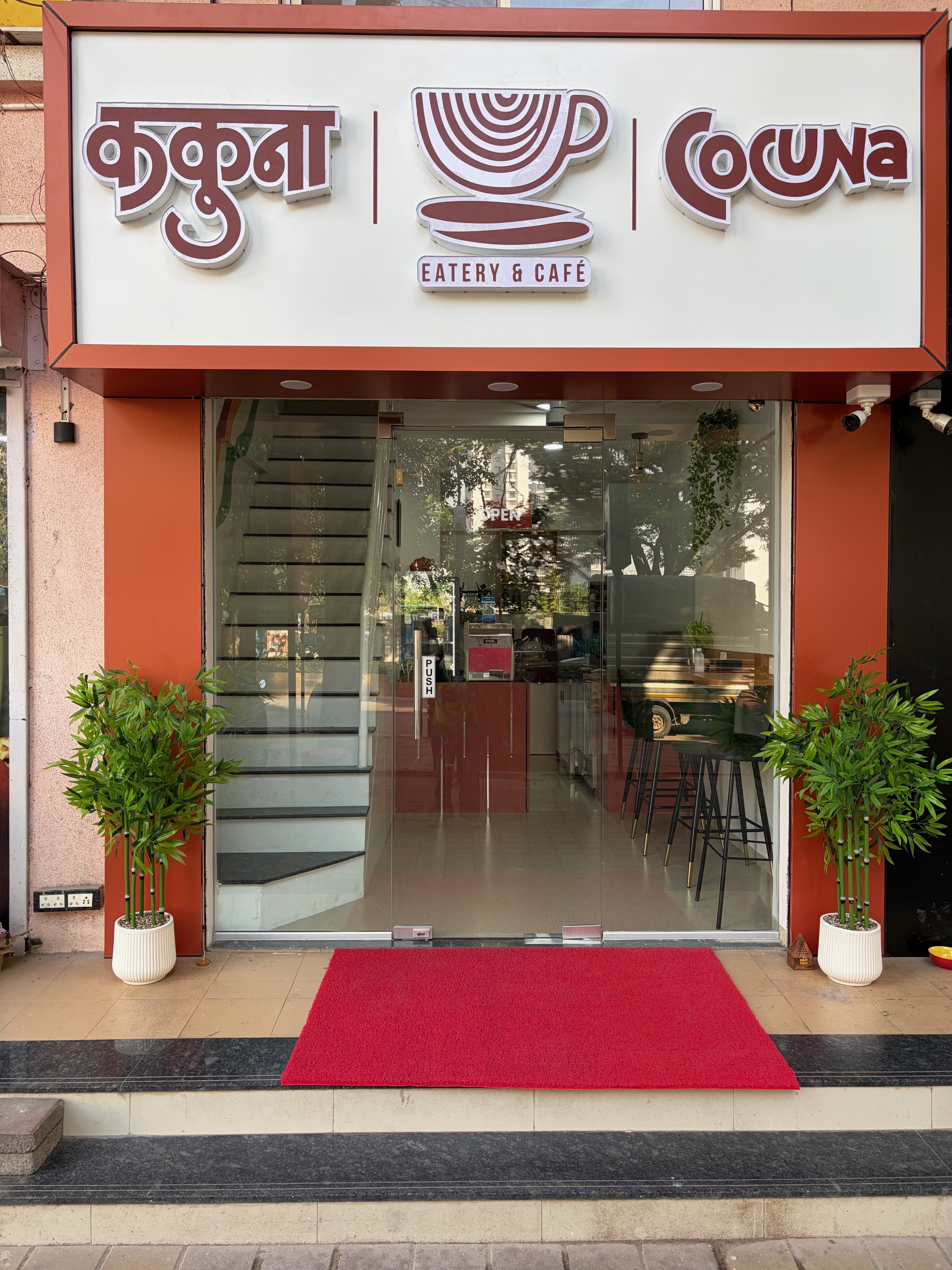 The entrance to Cocuna Eatery & Café, with terracotta signage and plants