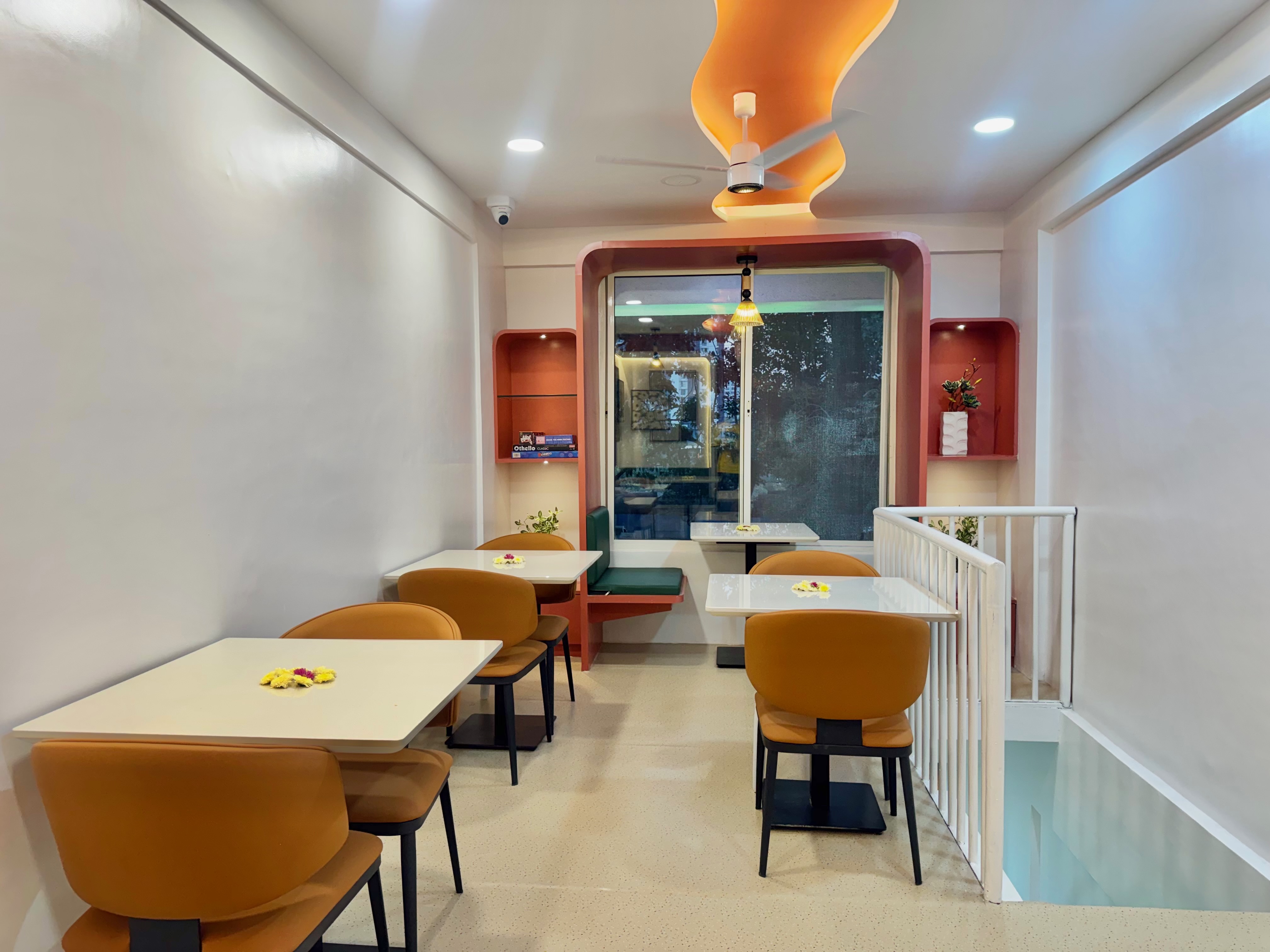 Cocuna’s upstairs seating, with mustard chairs and a warm curved ceiling