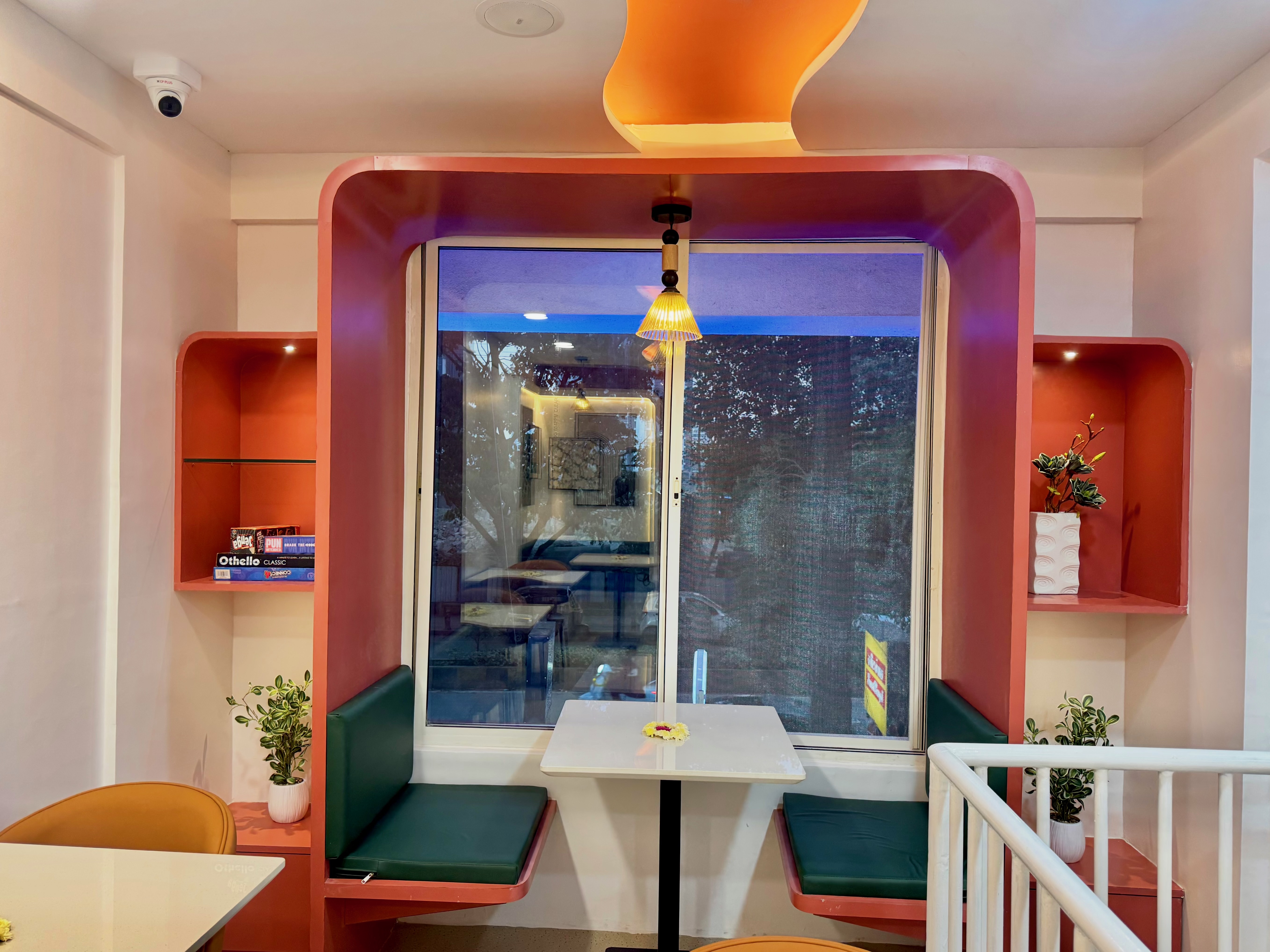 A table for two beside Cocuna’s terracotta-framed window and green seating